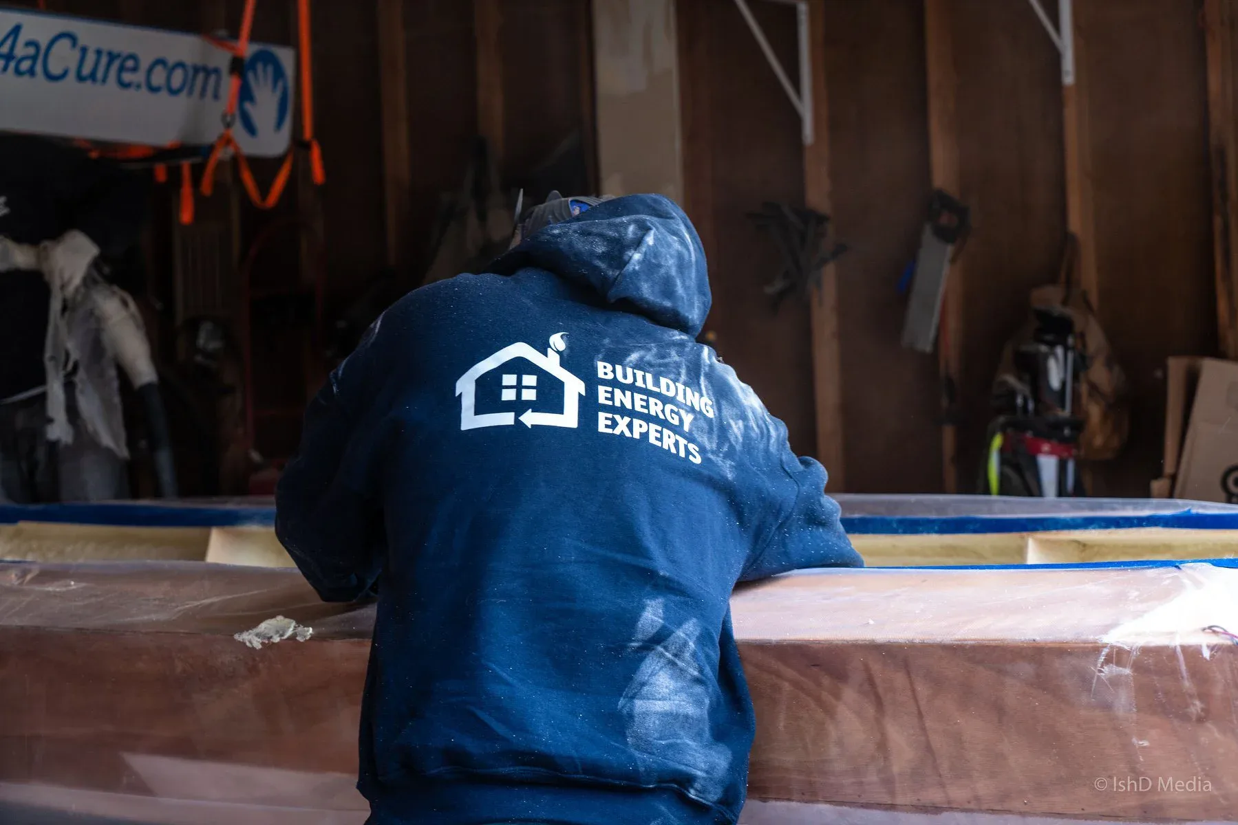 Building Energy Experts team member in branded workwear preparing materials at an indoor work area